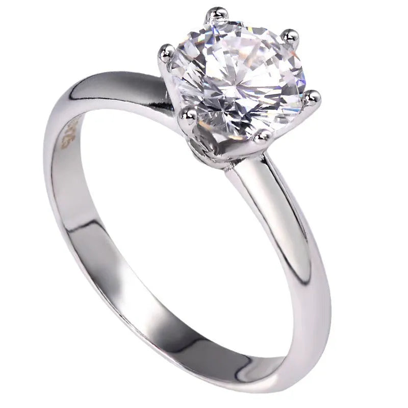 White gold plated geometric ring with a six-claw setting holding a central zircon stone.