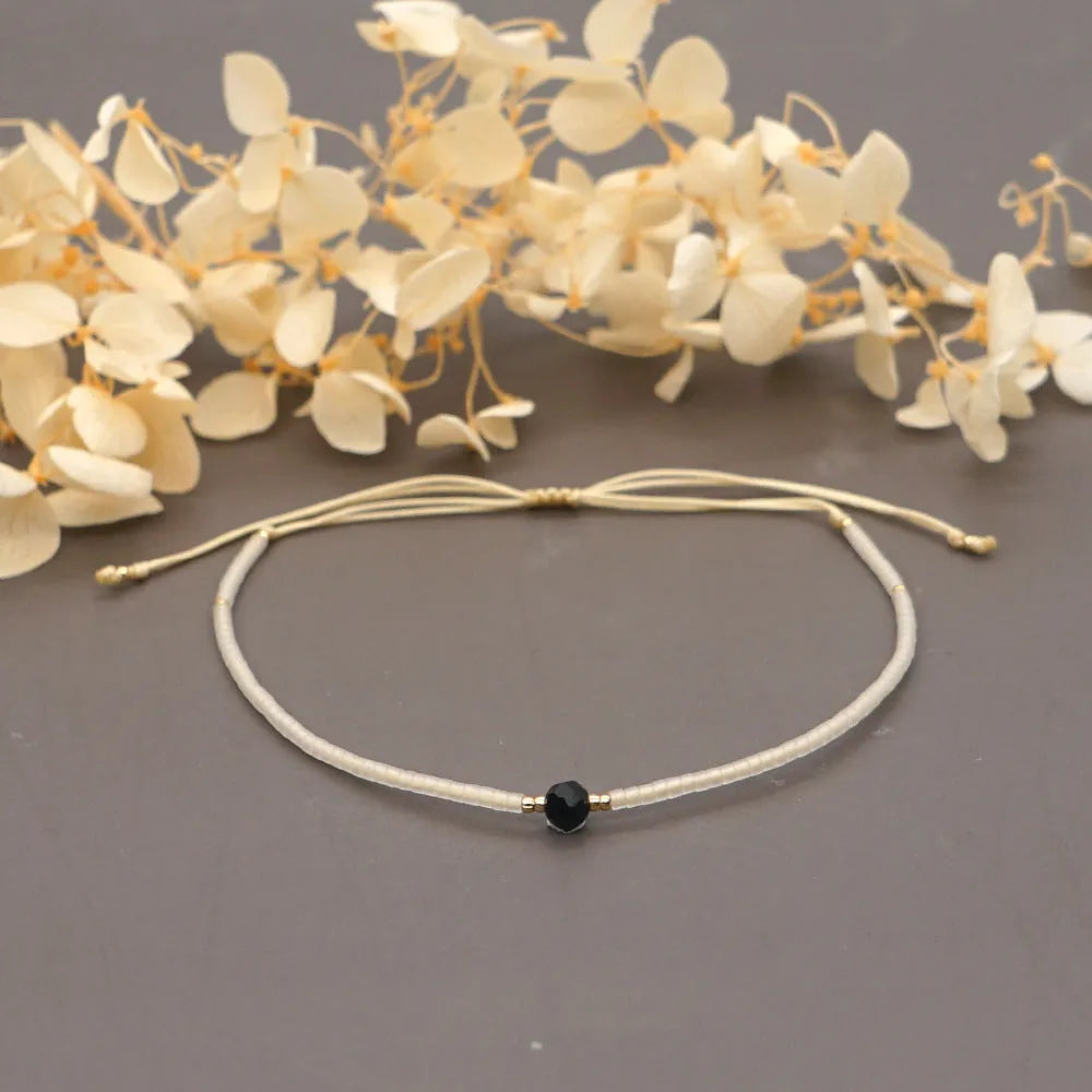 Handmade bohemian bracelet with colourful geometric glass beads on a female wrist.