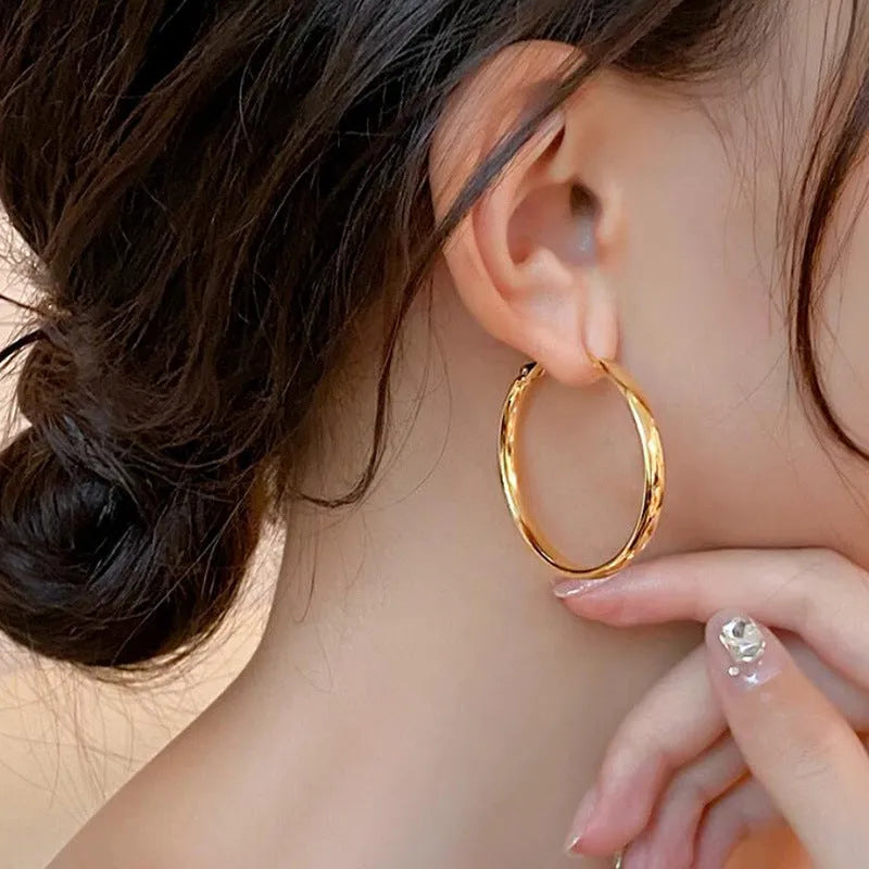 Circular metal earrings with 40mm diameter in gold and silver electroplated finishes