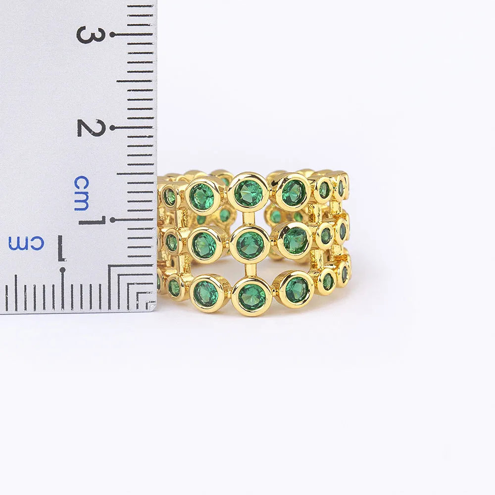 Wide gold-coloured ring with large green zircon stone on copper base with gold plating