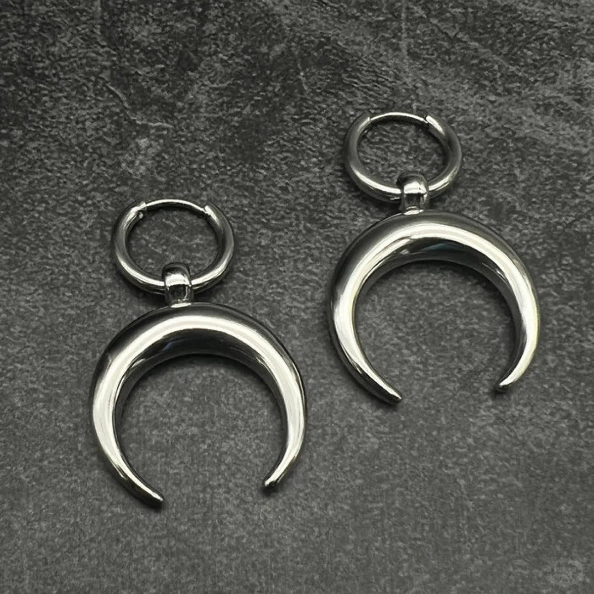 Silver alloy big hoop earrings with a gothic moon design and ear clip back.