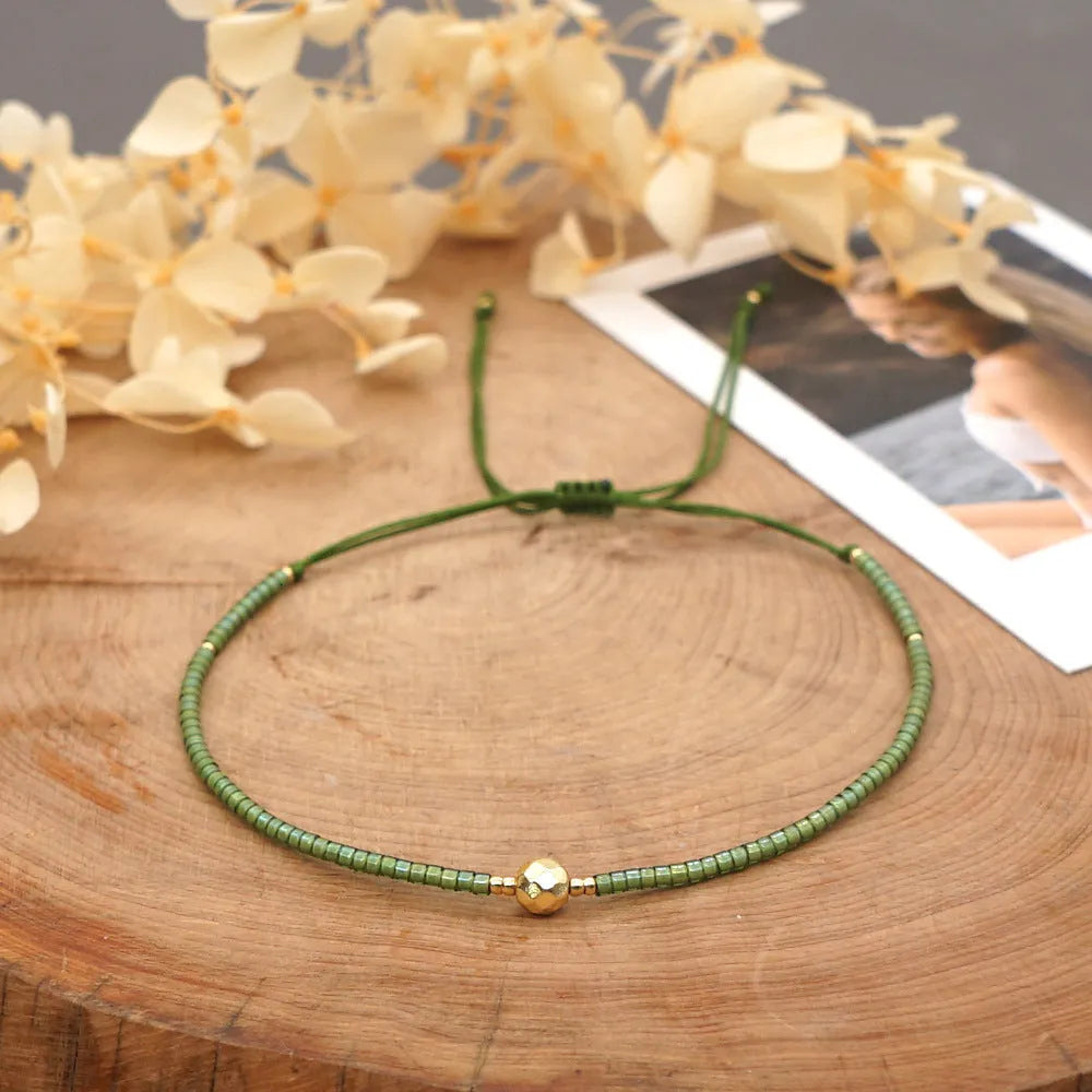 Handmade bohemian bracelet with colourful geometric glass beads on a female wrist.