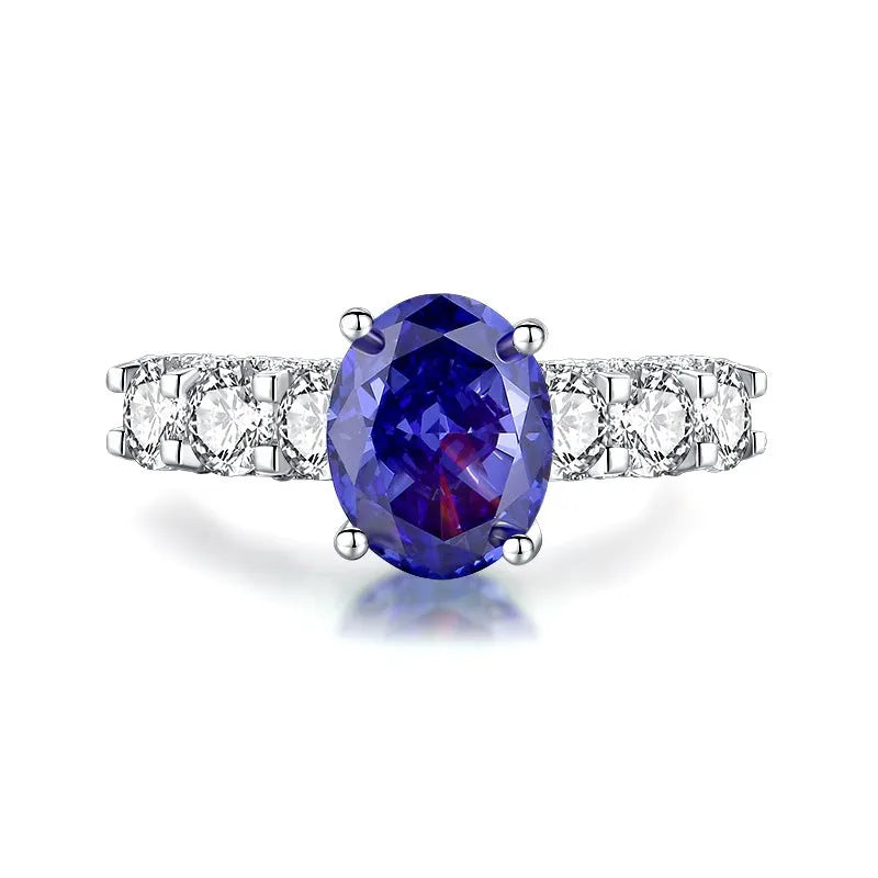 Heart shaped Tanzanite purple zircon ring in sterling silver on a grey background.