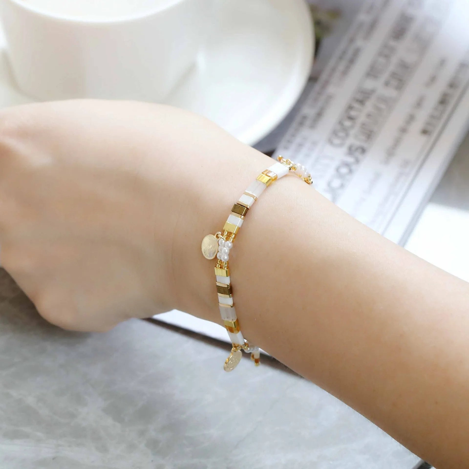 Handcrafted women's bracelet with imitation pearl beads in European style, showing colour variations.