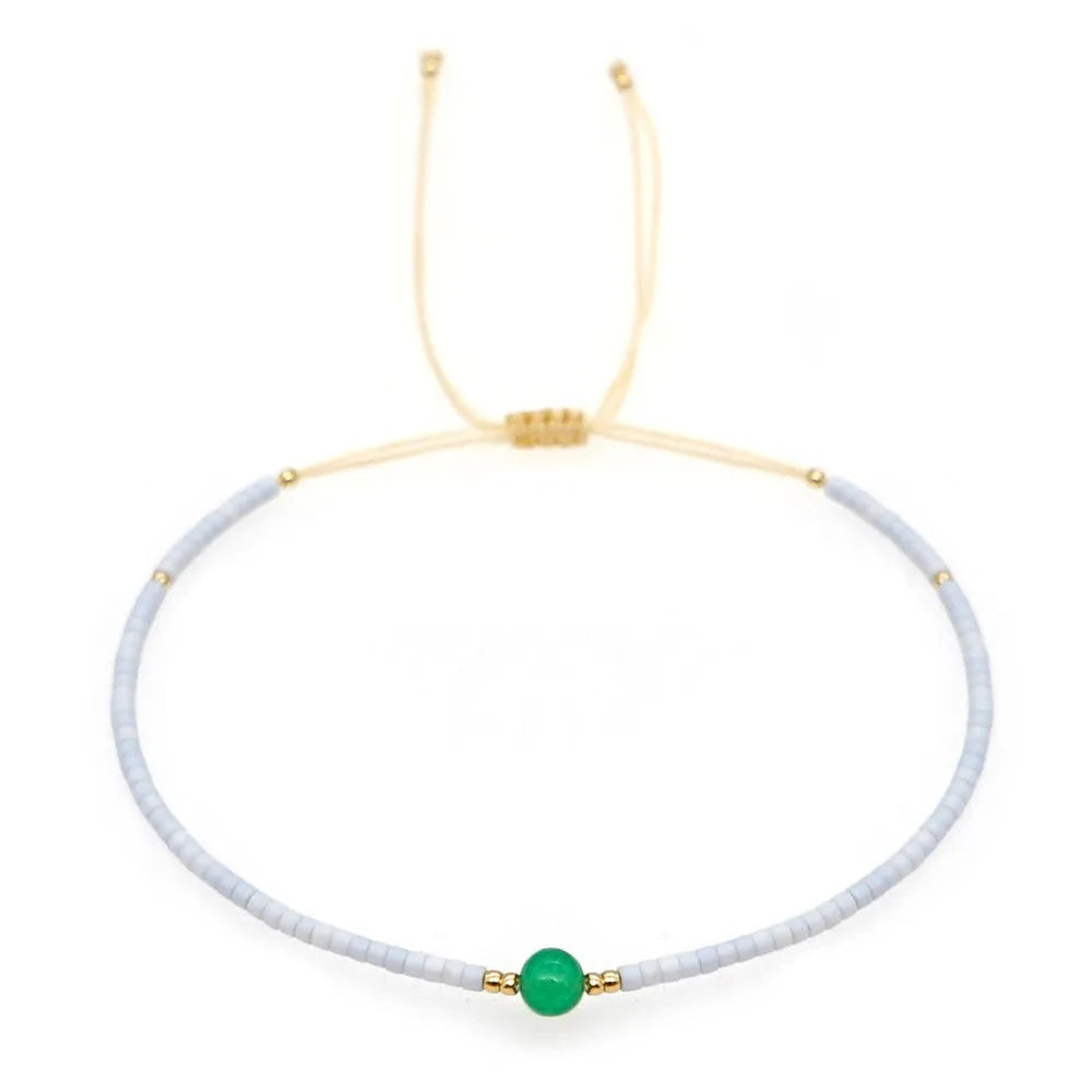 Handmade bohemian bracelet with colourful geometric glass beads on a female wrist.
