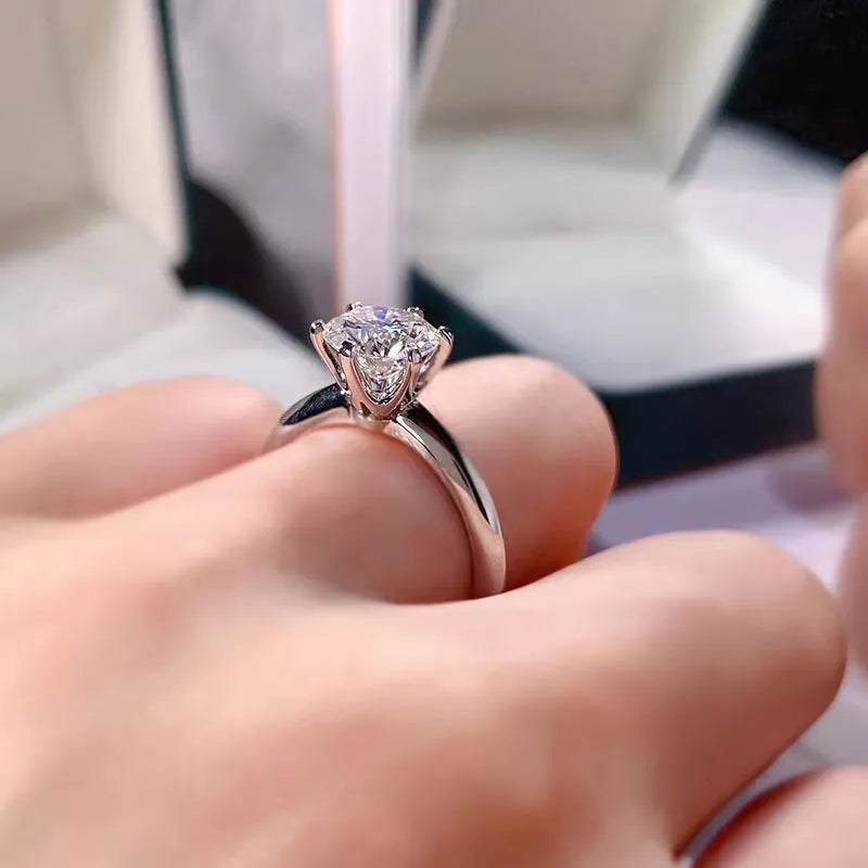 White gold plated geometric ring with a six-claw setting holding a central zircon stone.