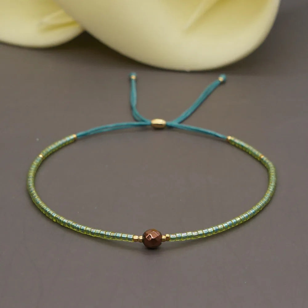 Handmade bohemian bracelet with colourful geometric glass beads on a female wrist.