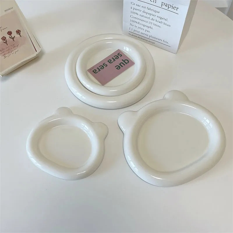 White porcelain plate with chubby toot or bear doodle pattern, shown in 15cm and 20cm round sizes.