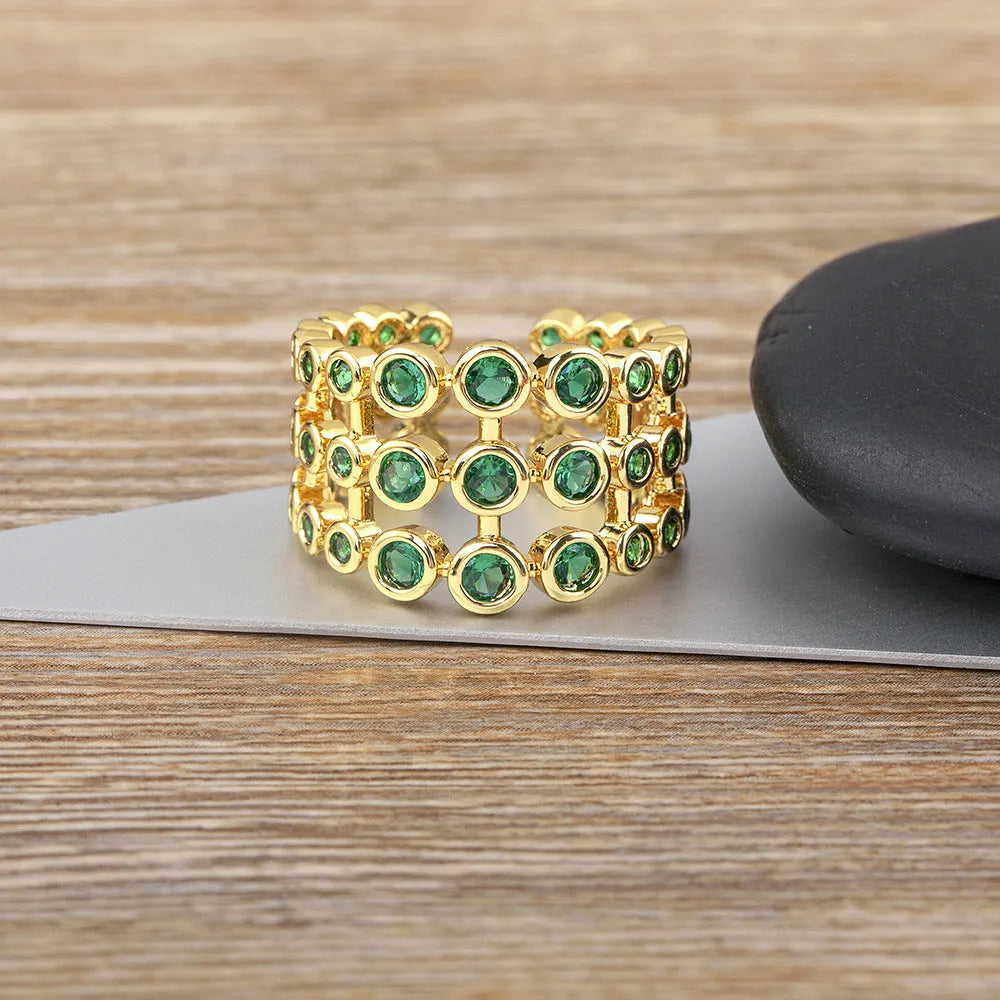 Wide gold-coloured ring with large green zircon stone on copper base with gold plating