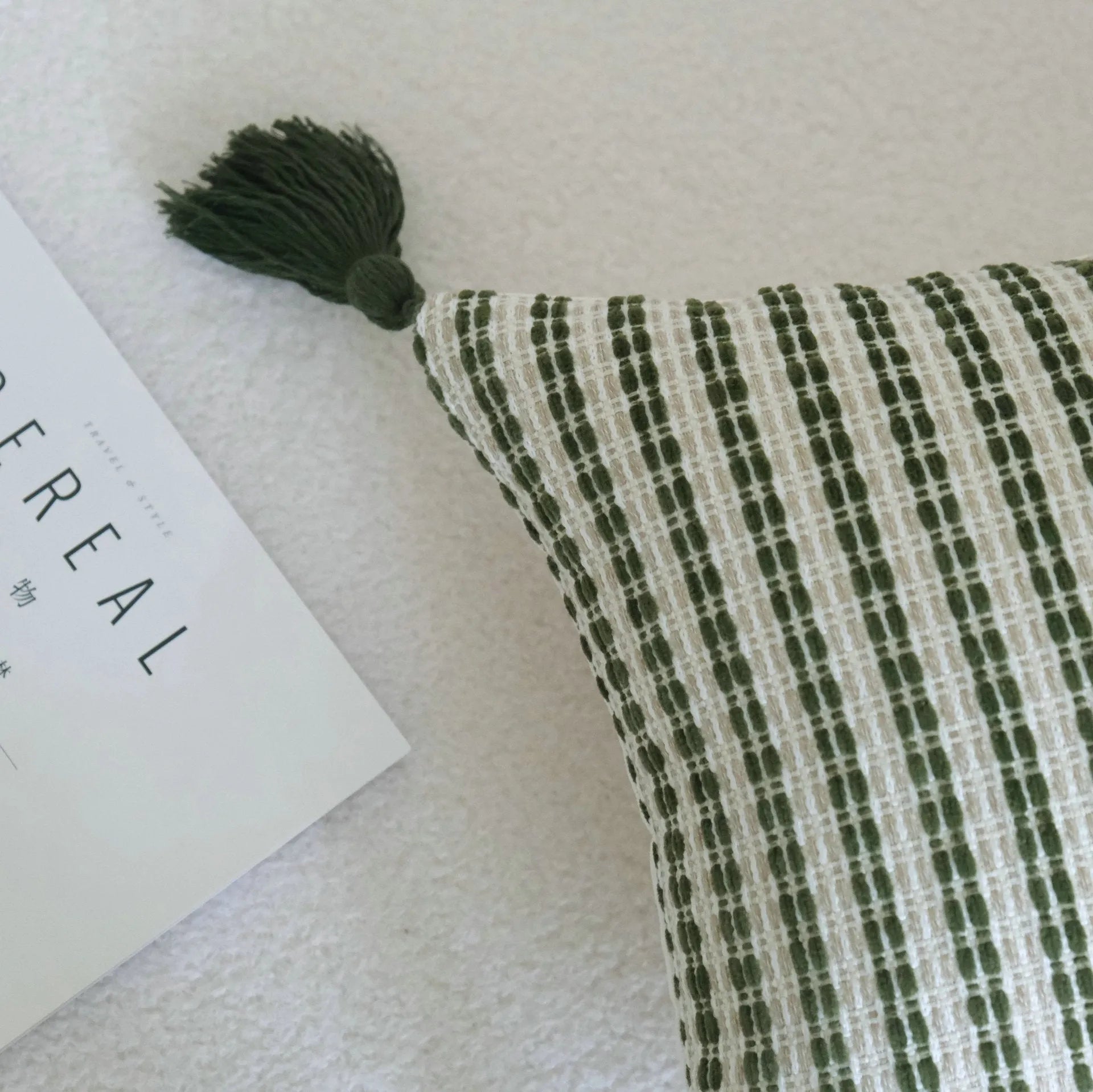 Green cotton and linen hotel sample pillow with tassel details and botanical patterns for display use