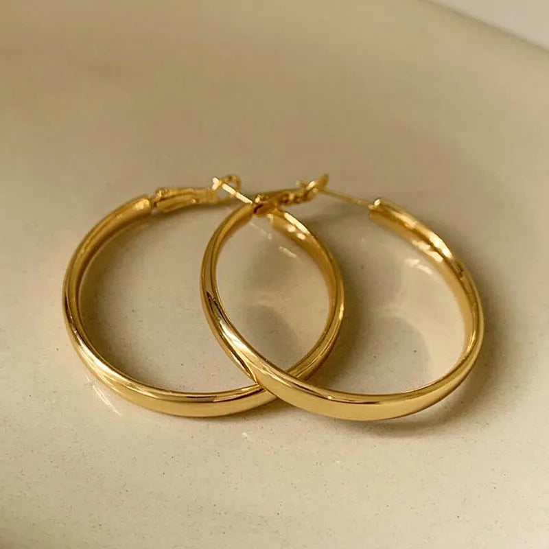Circular metal earrings with 40mm diameter in gold and silver electroplated finishes