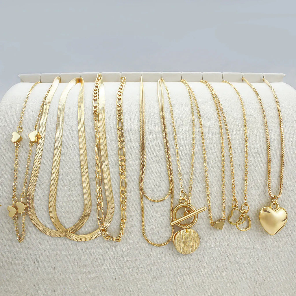 Gold-coloured women's necklace set showing ten pieces with simple alloy pendants on snake bone chains
