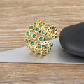 Wide gold-coloured ring with large green zircon stone on copper base with gold plating