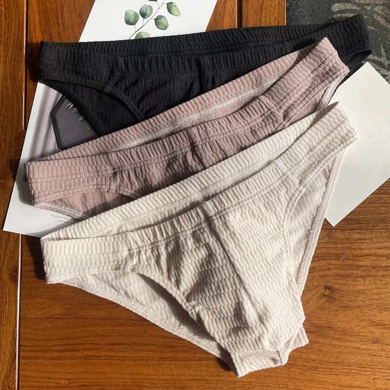 Men's solid colour cotton briefs with mid waist and triangle style in apricot black and skin colour.