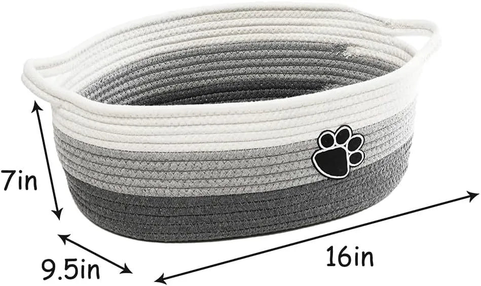 Light beige handmade woven cotton rope storage basket with a handle on a wooden surface.