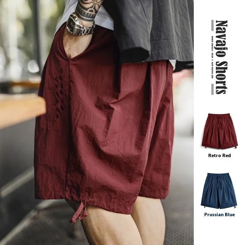 Men's loose fit nylon summer shorts in Prussian blue with embroidered design detail