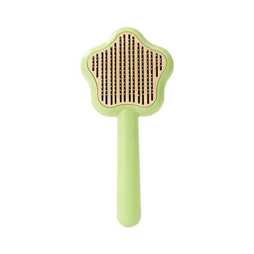 Green stainless steel self-cleaning cat comb with needle bristles on a white background.