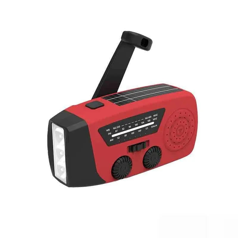 Red hand-crank emergency radio torch with solar panel, LED flashlight, and USB charging port.