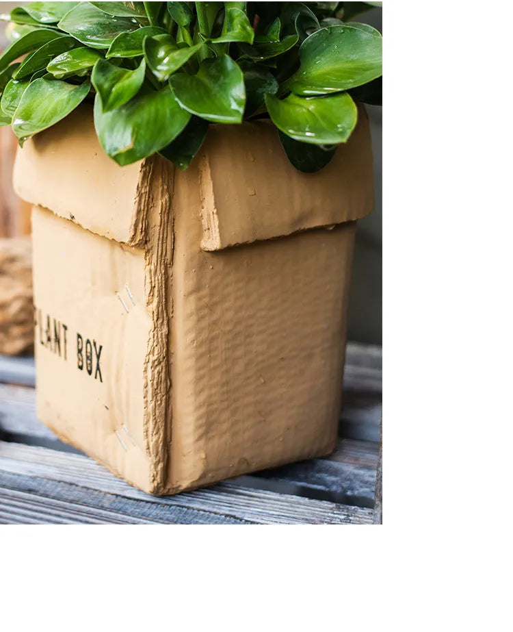 Cement flowerpot with brown paper box design featuring drainage holes
