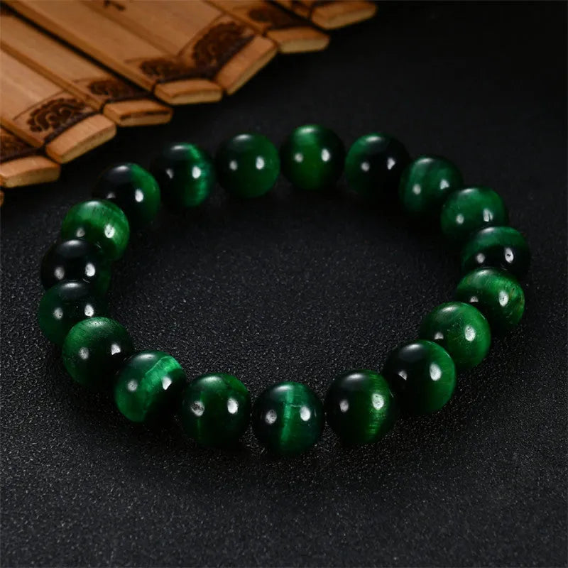 Polished green tiger eye stone bracelet with geometric beads in various sizes on wrist