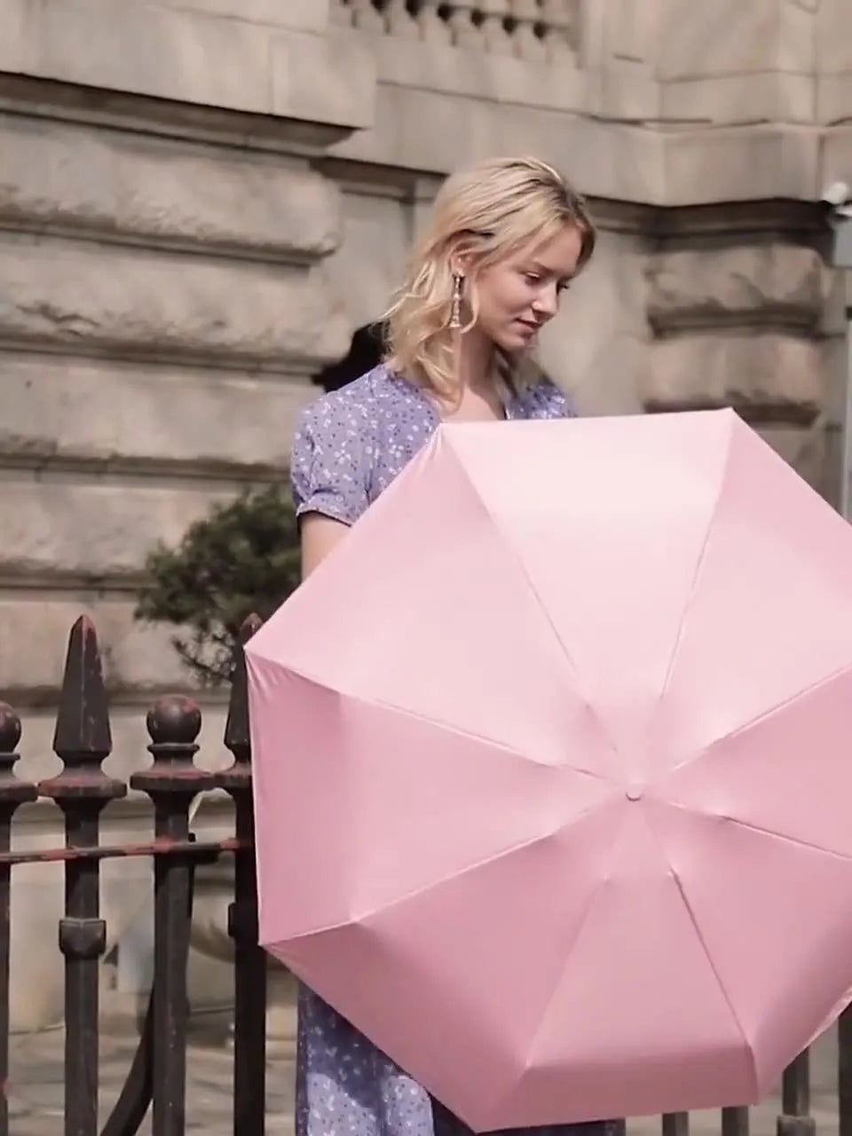 A folded six-fold flat umbrella in a capsule box, showing the steel ribs and rubber handle.