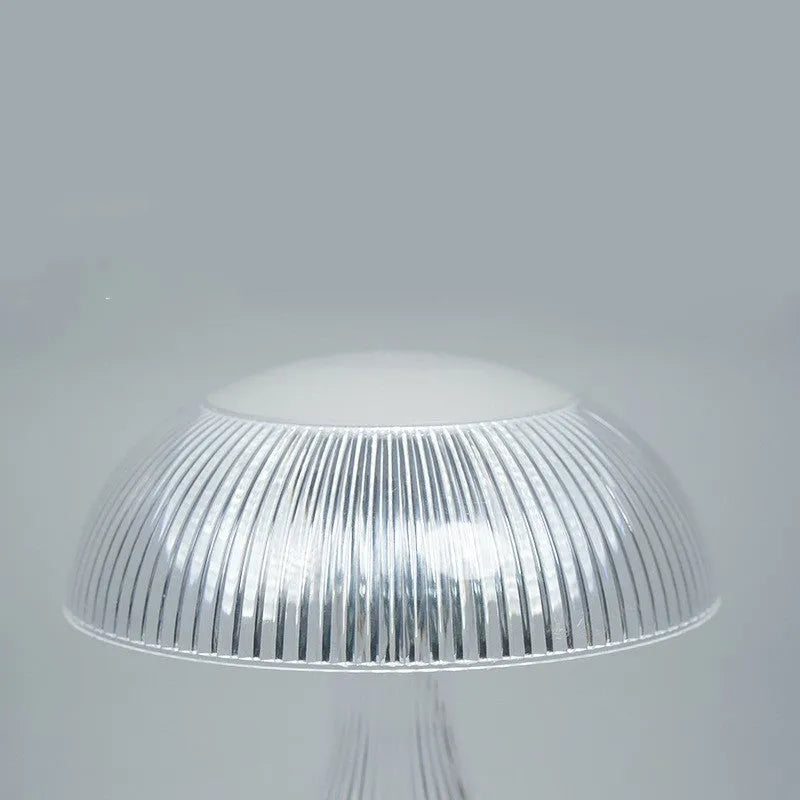 White rechargeable touch control bedside lamp with acrylic shade on a table.