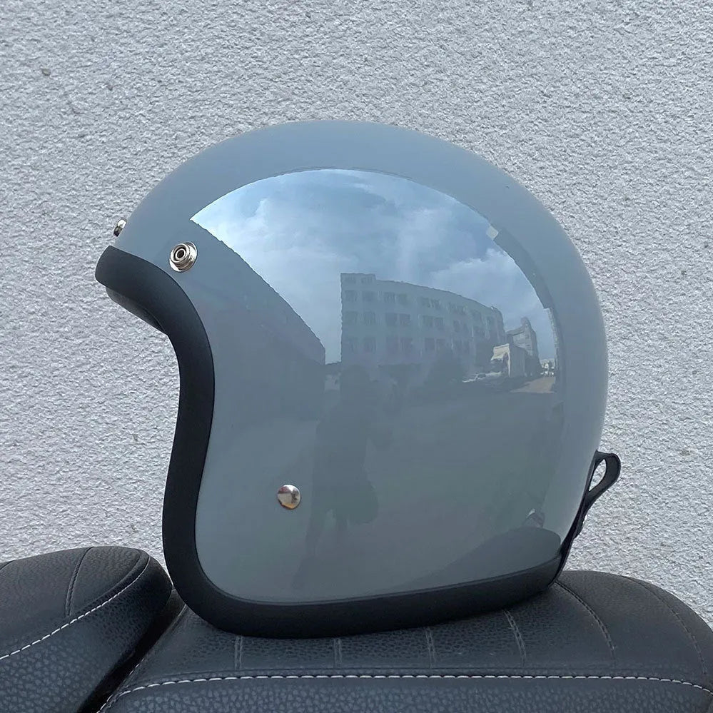 Glass fibre retro half motorcycle helmet shown in multiple colour options including cement grey and matte black flower patterns