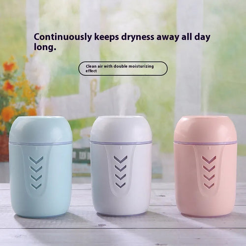 Round white portable air purifier with USB cable on a wooden desk.