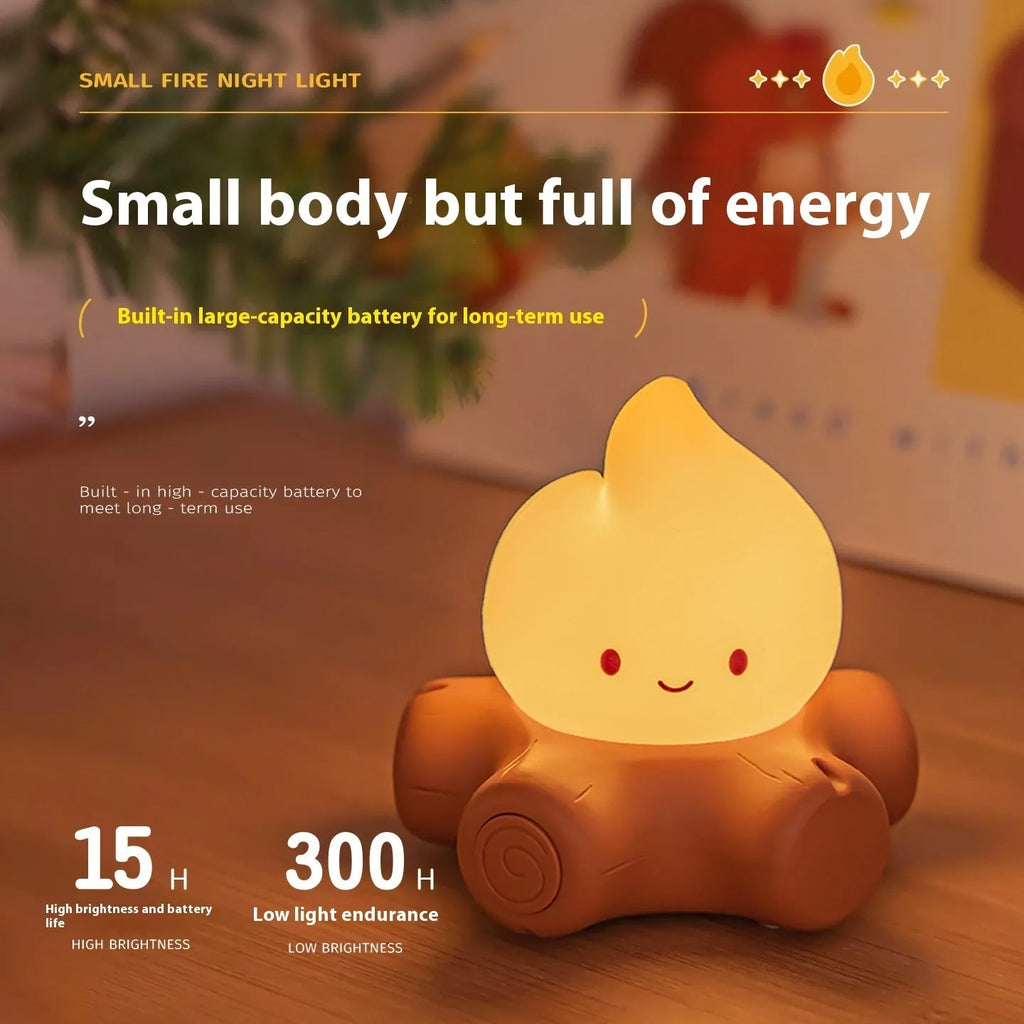 Silicone cartoon fire pile night light with yellow LED illumination on a bedside table.