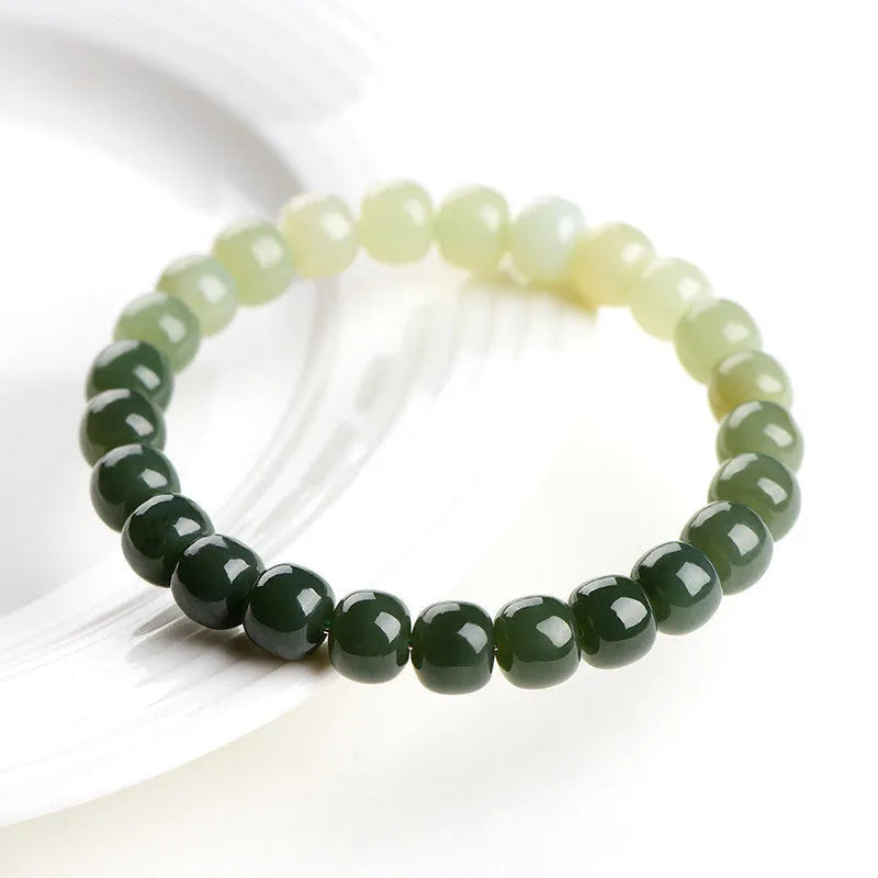 Natural Hetian jade bracelet with gradient clear water coloured beads on a wrist.