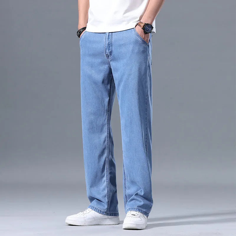 Man wearing loose fit light blue straight-leg lyocell jeans with a zip fly.