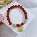 A red agate bracelet for women with Chinese style dragon and lucky bag motifs.