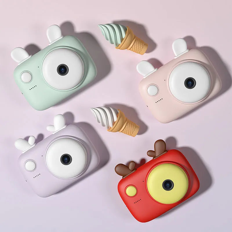 A2 Kids Macaron Mini SLR camera in green, pink, purple, or red with 2.4-inch screen, shown with lanyard.