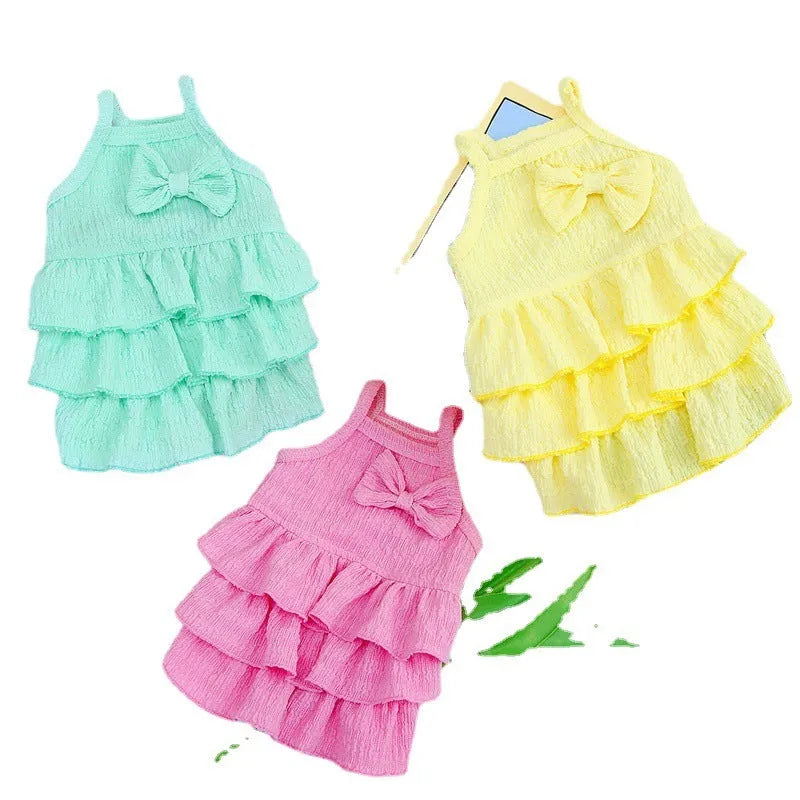 Small dog wearing a layered skirt princess dress in a candy colour.
