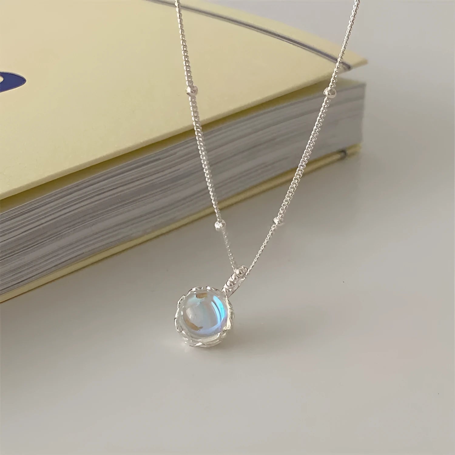 Silver necklace with geometrical ornamental stone pendant on an adjustable curb chain.