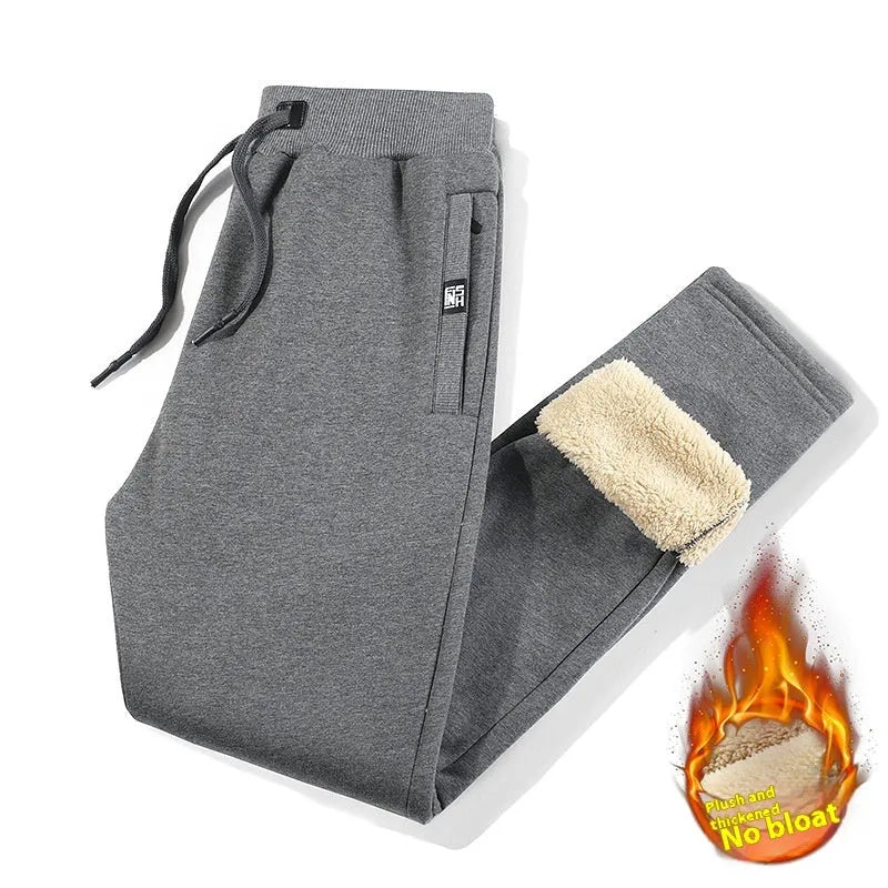 Men's grey oversized fleece-lined cotton track pants with drawstring waist on a hanger.
