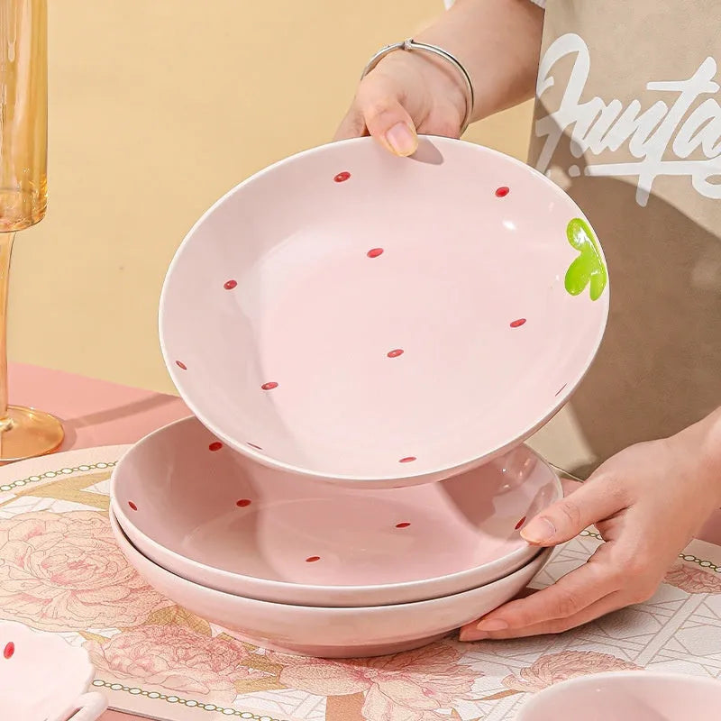 Porcelain dinnerware set with strawberry design showing plates, flower bowls, and twist spoon