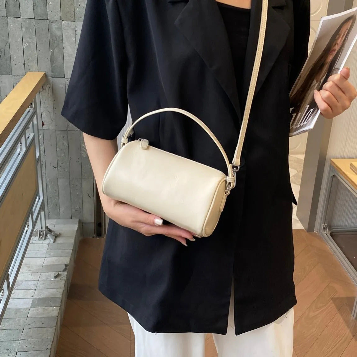 Soft vegetable-tanned leather crossbody phone bag in cylindrical shape with adjustable strap.