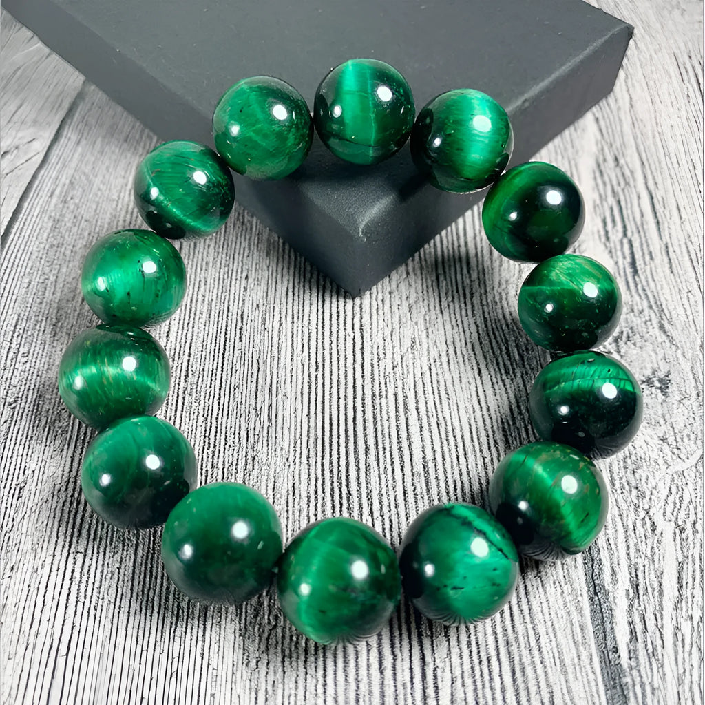 Polished green tiger eye stone bracelet with geometric beads in various sizes on wrist