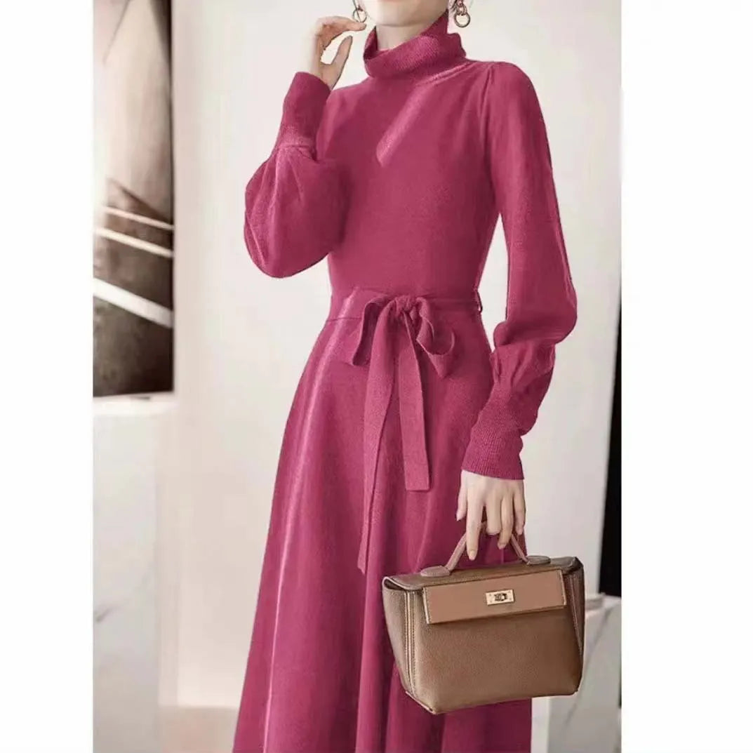 Loose-fitting turtleneck knit dress in rose red with long sleeves and a mid-length skirt.