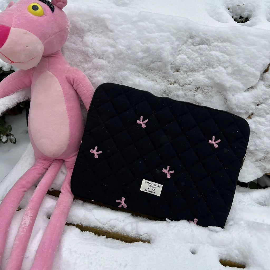 Cute white nylon laptop bag with a rhombus embroidered bow, shown next to a laptop.