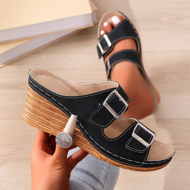 Women's creamy-white beach slippers with an outer wedge belt buckle on a flat rubber sole.
