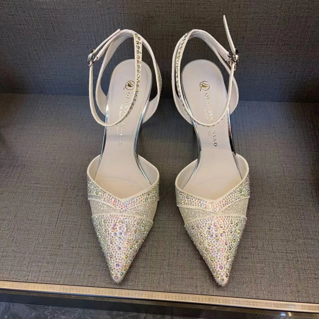 Women's silver and black hollow high heels with red sole and pointed toe design