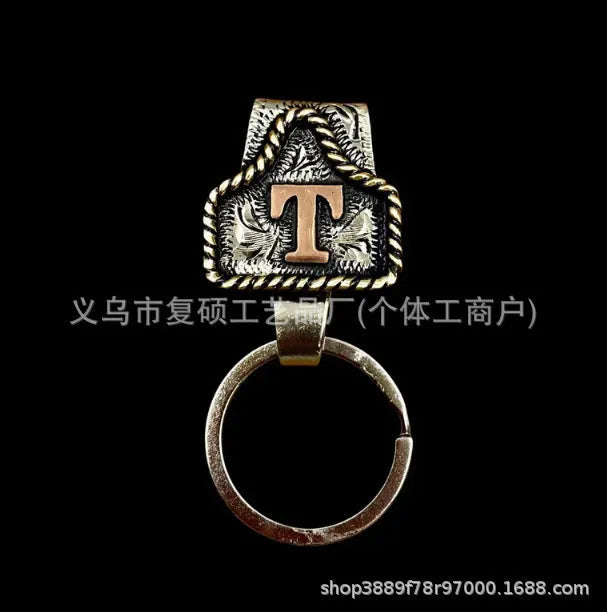 Handmade metal cow tag belt key holder keychain on a key ring, showing the metal loop and tag design.