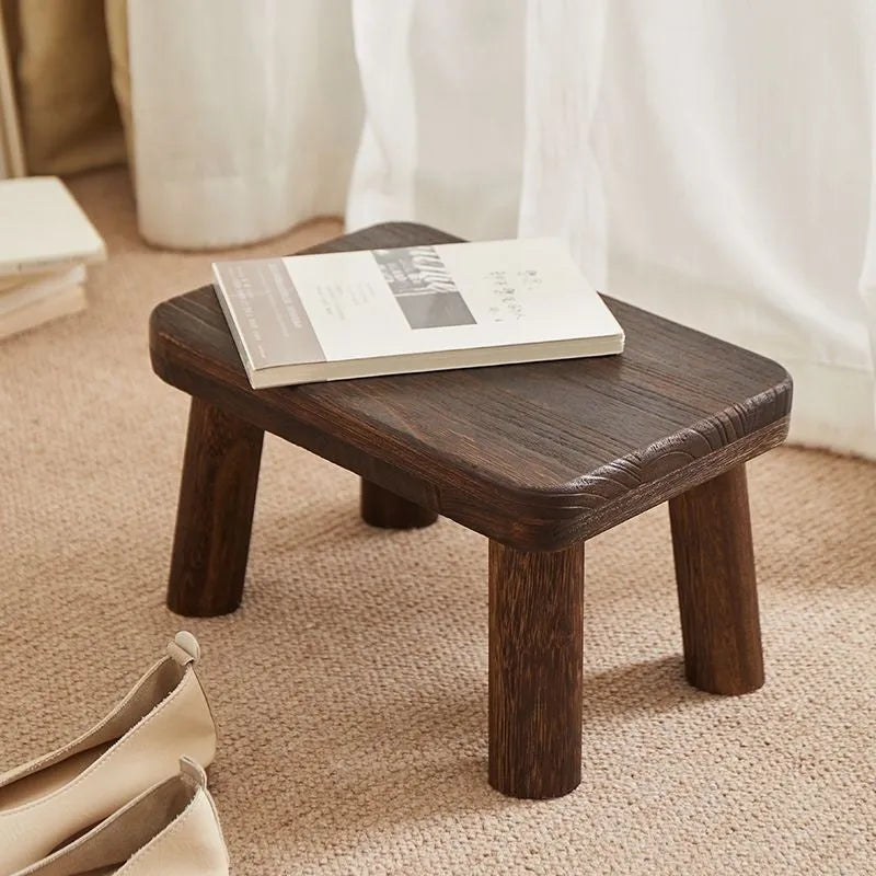 Solid wood shoes changing stool with distressed finish and bracket leg structure.