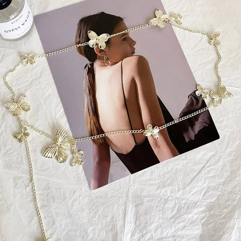 Gold and silver butterfly motif waist chain jewellery belt for women on a plain background.