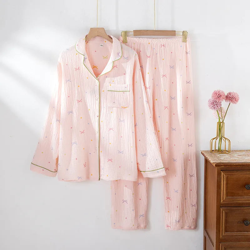 Women's beige long sleeve cotton pajama top and trousers set laid flat.