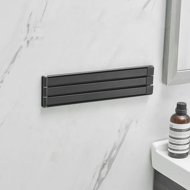 Nordic-style folding towel rack in black or white with adhesive mounting system