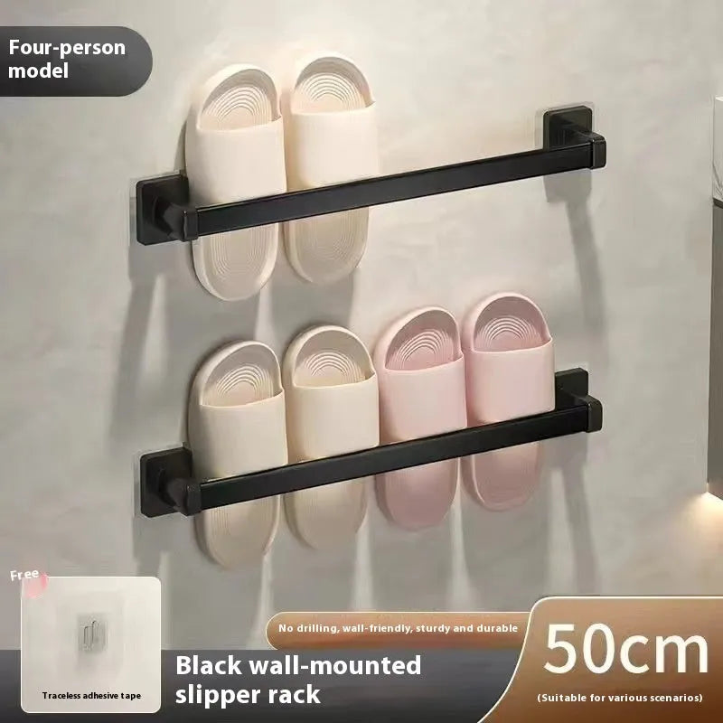 Black wall-mounted slipper rack with a small seat, shown holding two pairs of slippers.