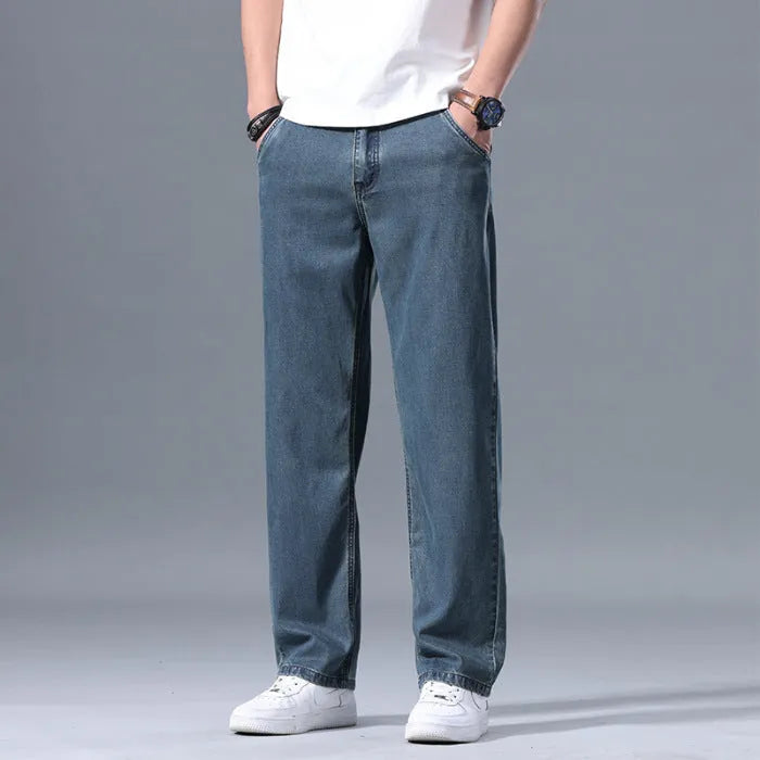 Man wearing loose fit light blue straight-leg lyocell jeans with a zip fly.